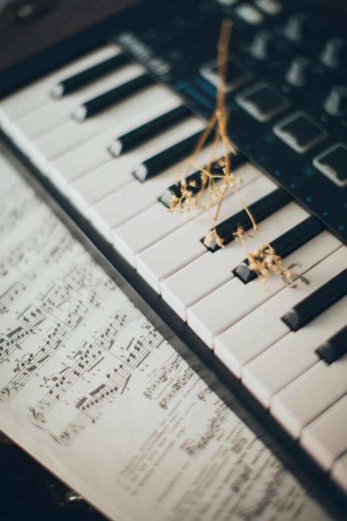 pexels-photo-3971983-3971983 Close-up of piano keys with a flower and sheet music creates an artistic and musical ambiance.